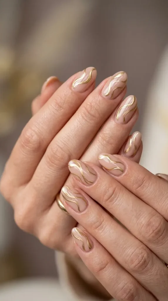 Nude nails with abstract gold swirl art