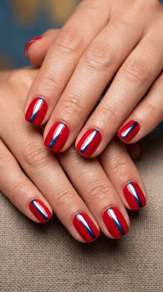 Red nails with chrome blue accent stripe