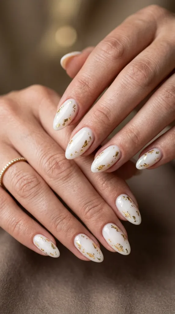 Milky white almond nails with gold foil accents