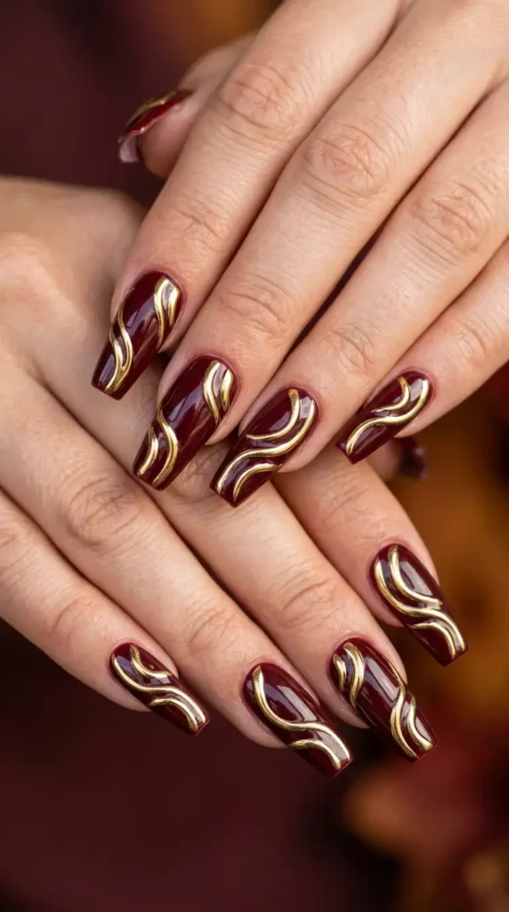 Burgundy Nails with Gold Chrome Swirls