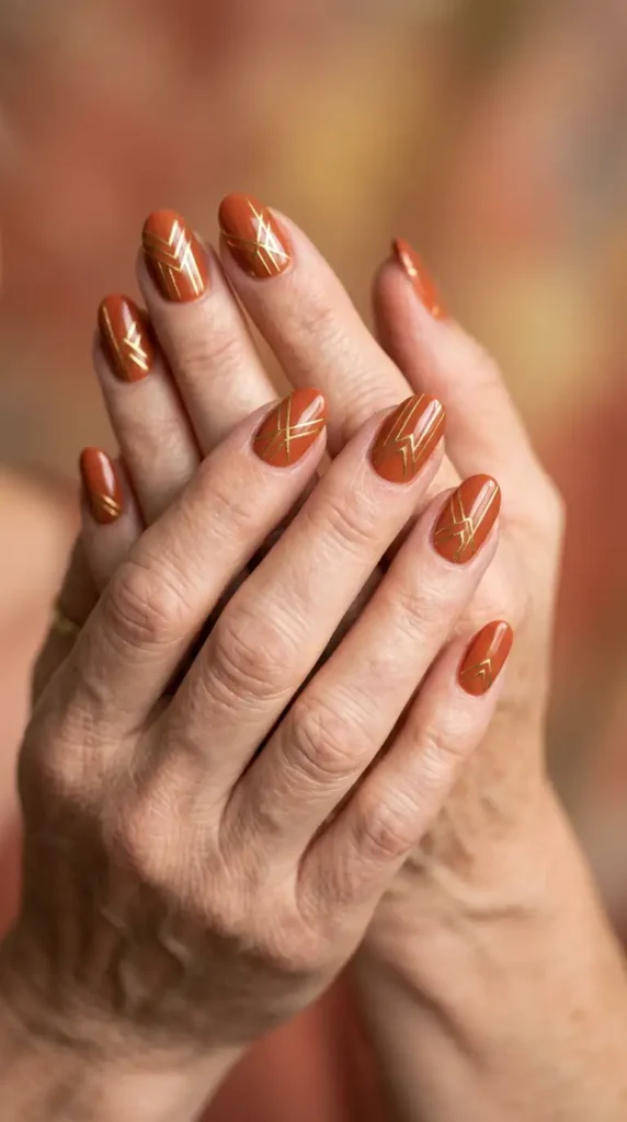 Burnt Rust Oval Nails with Metallic Gold Lines