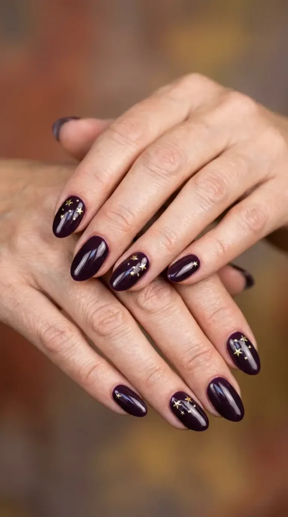 Dark Plum Oval Nails with Gold Star Accents